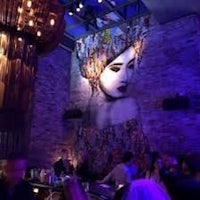 a group of people are sitting at a bar in a dark room